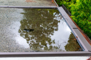 Ponding standing water on a flat roof after heavy rain